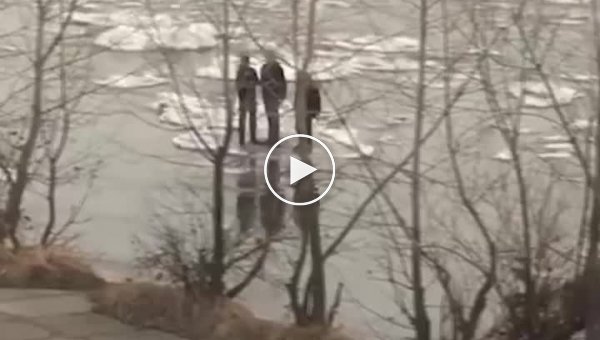 Мужчины плывут по реке на льду